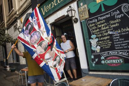 Un hombre sostiene una bandera con imágenes de la reina Isabel II, en una calle de Gibraltar, este viernes.