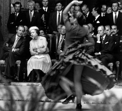El rey Juan Carlos charla con la reina Isabel II Inglaterra durante una exhibición de flamenco en la visita de los monarcas a Sevilla. A la derecha de la imagen, el príncipe Felipe de Edimburgo.