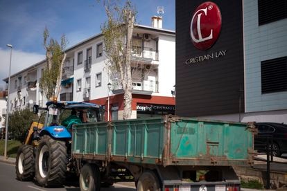 Un tractor con un remolque pasa por delante de la sede de CL Grupo Industrial, en Jerez de los Caballeros (Badajoz).