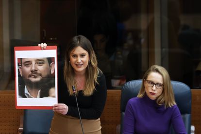 La líder de Unidas Podemos, Alejandra Jacinto, muestra una fotografía del hermano de Isabel Díaz Ayuso, Tomás Díaz Ayuso, en el pleno de la Asamblea de Madrid celebrada este jueves.