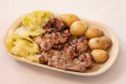 Plato del día de secretos de cerdo negro con patatas y repollo.