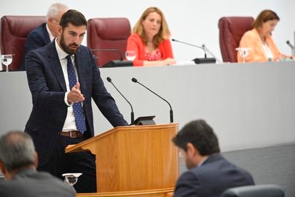 El presidente de Vox en Murcia, José Ángel Antelo, interviene durante la segunda reunión del debate de investidura, en la Asamblea Regional, este viernes en Cartagena. A la derecha, sentado, el candidato a la reelección como presidente, el popular Fernando López Miras.