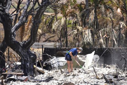 Una mujer cava entre los escombros de una casa destruida por el incendio forestal, este viernes 11 de agosto, en Lahaina (Hawái).