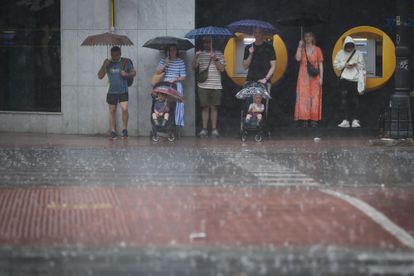 Un grupo de personas se refugia de la intensa lluvia el sábado en Valencia.
