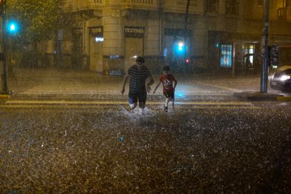 Dos peatones atraviesan un paso de cebra en Pamplona, el viernes.