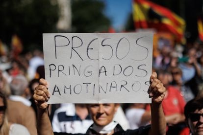Una persona sujeta una pancarta durante la manifestación organizada por el PP, este domingo en Madrid.