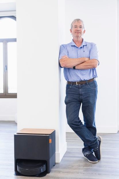 Colin Angle posa junto a la Roomba J9+, cuya nueva estación de anclaje permite cambiar el agua para el fregado y vaciar el depósito de residuos, dándole 60 días de autonomía.
