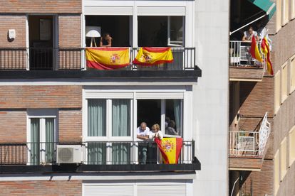 Vecinos miran por los balcones durante el acto del PP celebrado en Madrid, este domingo.