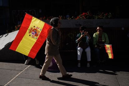 Varias personas con la bandera de España caminaban por el centro de Madrid antes del mitin convocado por el PP.