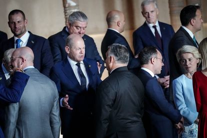 El canciller alemán, Olaf Scholz, conversa con el primer ministro húngaro, Viktor Orbán, tras la foto de familia en el Patio de los Leones de la Alhambra de Granada.