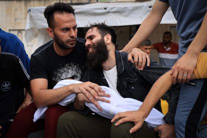 Un hombre sostiene este domingo el cuerpo de su hijo, que murió en un bombardeo, antes de su entierro en Jan Yunis, al sur de la franja de Gaza. 