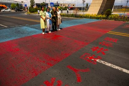 Visitantes del Centro de Cooperación Internacional Transfronterizo, una zona de libre comercio entre China y Kazajistán, se retratan sobre la línea que marca la frontera entre ambos países.