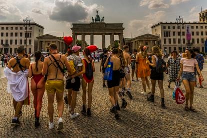 Un grupo de gente pasea por la puerta de Brandemburgo al finalizar el desfile del día del orgullo LGBT en Berlín.
