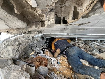 Un hombre intenta sacar el cuerpo de un familiar de entre los escombros tras el bombardeo del campo de Maghazi.