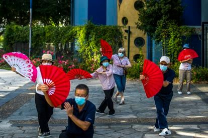 Residentes del barrio asiático de París (Francia) practican bailes tradicionales chinos en un parque de la zona.