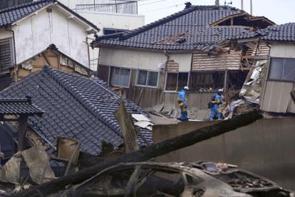 Personal de emergencias buscan supervivientes entre los escombros de varias viviendas colapsadas tras el seísmo en Wajima, este martes.