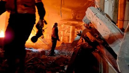 Personal de emergencias permanece entre los escombros de un edificio bombardeado por Israel, este lunes en Rafah.