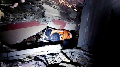 Un miembro de la Defensa Civil Palestina busca supervivientes entre los escombros de un edificio bombardeado por el ejército israelí, este lunes en Rafah.