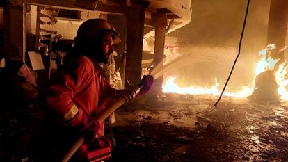 Un miembro de la Defensa Civil Palestina lucha contra las llamas tras los ataques israelíes sobre la ciudad de Rafah, al sur de la franja de Gaza, este lunes.