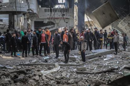 Un grupo de palestinos observa las ruinas de la mezquita del Al Huda, uno de los edificios destruidos este lunes por el bombardeo israelí en Rafah.