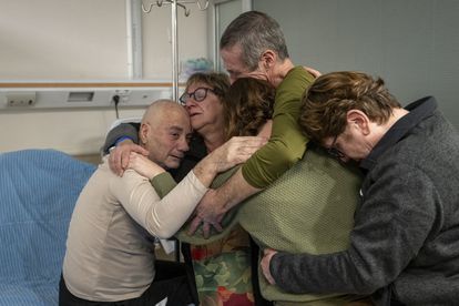 Los argentinos-israelíes Fernando Simón Marman (segundo por la derecha) y Norberto Luis Har (izquierda), tras ser rescatados este lunes se reúnen con sus familias en el Centro Médico Sheba.