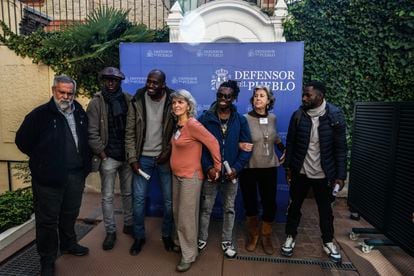 A la izquierda, Javier Baeza, párroco, junto a Blanca Aller, representante de Alcalá Acoge (centro) y María G, de Sercade (derecho), y a algunos de los migrantes.