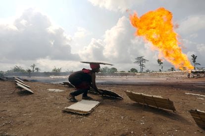 Una mujer frente a la llama de un pozo petrolero en Ughelli (Nigeria).