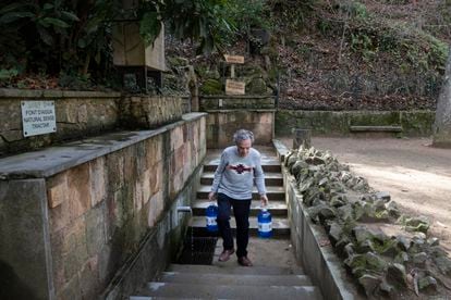 Un vecino recoge agua en la fuente Font Vella, en Sant Hilari Sacalm (Girona).