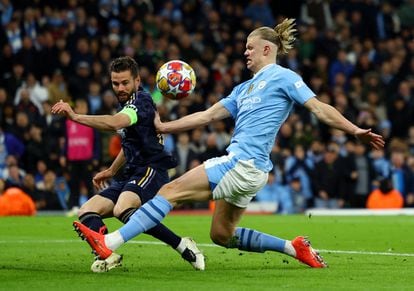 Nacho del Real Madrid corta un ataque de Haaland del Manchester City.