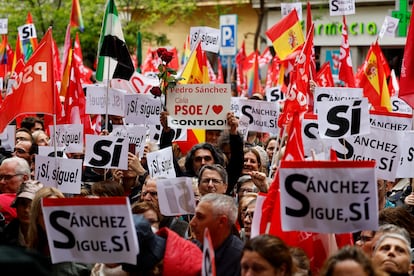 Manifestantes sostienen banderas del PSOE frente a la sede del partido en Madrid.