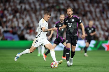 Toni Kroos del Real Madrid, conduce el balón ante la presencia de Harry Kane, del Bayern.