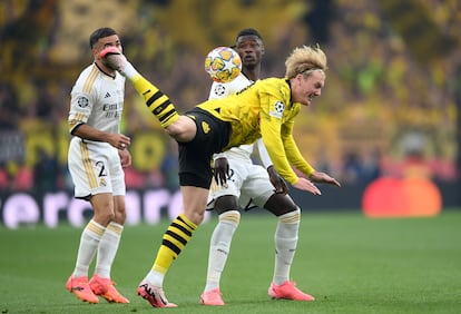 Julian Brandt corta un balón de forma acrobátic, ante Camavinga y Carvajal del Real Madrid.