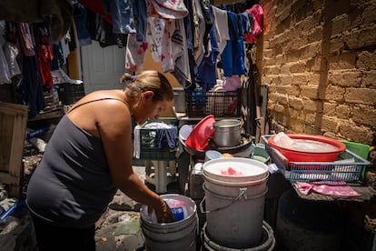 Elizabeth Pinzón Ramírez muestra el agua que almacena en cubetas, en la delegación Iztapalapa, el día 11 de junio de 2024.