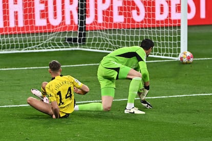 Courtois mira como el disparo de Niclas Fuellkrug del Dortmund pega en el poste.