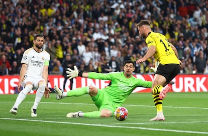 Niclas Fullkrug del Dortmund controla el balón ante Courtois del Real Madrid.