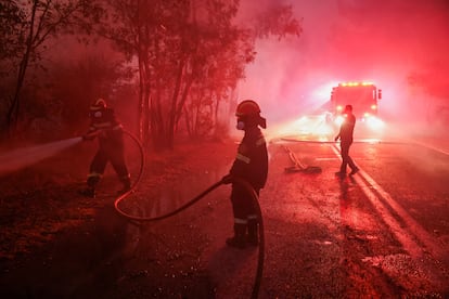 Varios bomberos participan en las labores de extinción del incendio en Dionysos, este lunes.