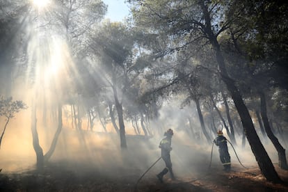 Los bomberos intentan extinguir el incendio forestal en Patima Halandri, un suburbio de Atenas (Grecia), el martes.