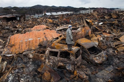 Un rescatista busca cuerpos en las ruinas de Kesennuma (390 kilómetros al noreste de Tokio) tras el terremoto, incendio y tsunami que asoló la zona en 2011.