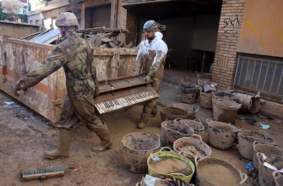 En un oscuro garaje en Massanassa, una escuela de música,   trabajan varios soldados llenos de barro. Los instrumentos estropeados por el lodo se amontonan en un contenedor, el 27 de noviembre. El último es un pequeño piano que ningún alumno volverá ya a tocar.