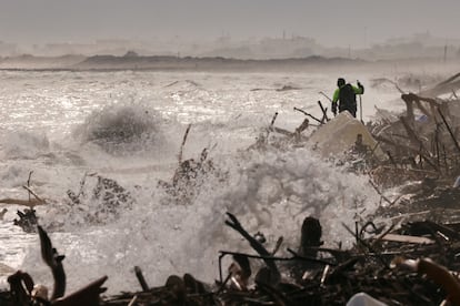 Un voluntario busca víctimas en la orilla de la playa del Saler (Valencia), este lunes.