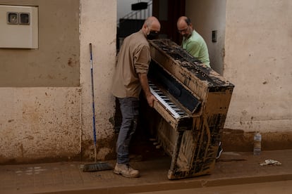 Miguel Ramírez retira de su casa un piano inutilizado por la fuerza del agua, el 5 de noviembre. El instrumento, comprado por su esposa Lupe Murcia con sus ahorros a los 17 años, tiene un gran valor sentimental. La noche de la inundación, sus hijos lograron subir otros instrumentos a la planta superior, pero no llegaron a tiempo para salvar el piano, que hasta media hora antes de la riada estaba tocando su hija.