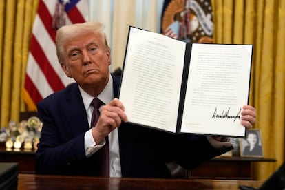 Donald Trump muestra uno de los decretos firmados este jueves en el Despacho Oval de la Casa Blanca.