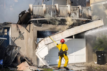 Un bombero lucha contra el fuego en el garaje de una vivienda a punto de desmoronarse en Pacific Palisades, en el condado de Los Ángeles, California.