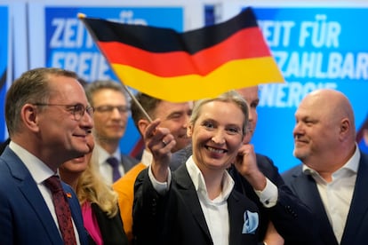 La líder del partido ultraderechista AfD, Alice Weidel, ondea una bandera alemana en la sede del partido en Berlín.