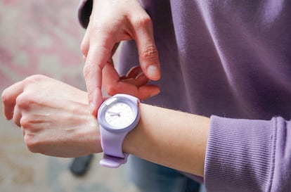 Una persona modificando la hora de su reloj.