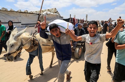 Gazatíes cargan suministros de ayuda que recibieron de la polémica Fundación Humanitaria de Gaza, en Jan Yunis, este miércoles.