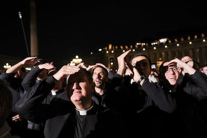 Un grupo de clérigos reacciona al humo negro de la chimenea de la Capilla Sixtina.