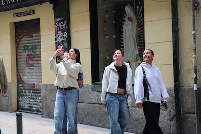 Un grupo de amigas turistas se paran a tomar fotos a la sesión de Leo Rizzi en El Balcón de la Calle Pez, en Madrid, el domingo 13 de abril de 2025.