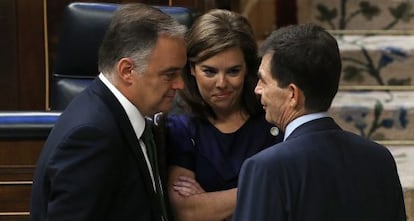 José Enrique Serrano (d), ponente socialista en el pleno de la Ley de Transparencia, conversa con la vicepresidenta del Gobierno, Soraya Sáenz de Santamaría (c) y el diputado popular Esteban González Pons, en 2013.
