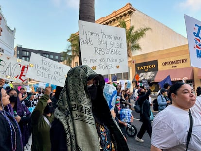 El martes, los manifestantes sostenían un cartel mientras escuchaban a los organizadores comunitarios frente al antiguo juzgado del condado de Orange en Santa Ana.